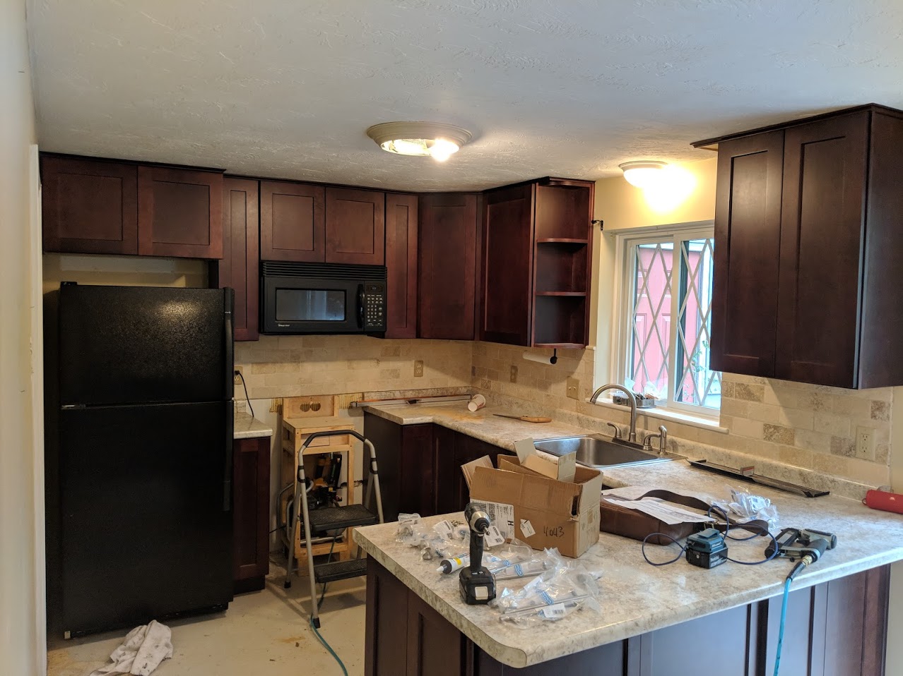 A work-in-progress kitchen with Cherry-color cabinetry.