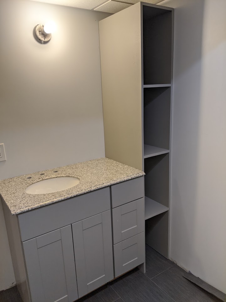 A bathroom with gray cabinetry.