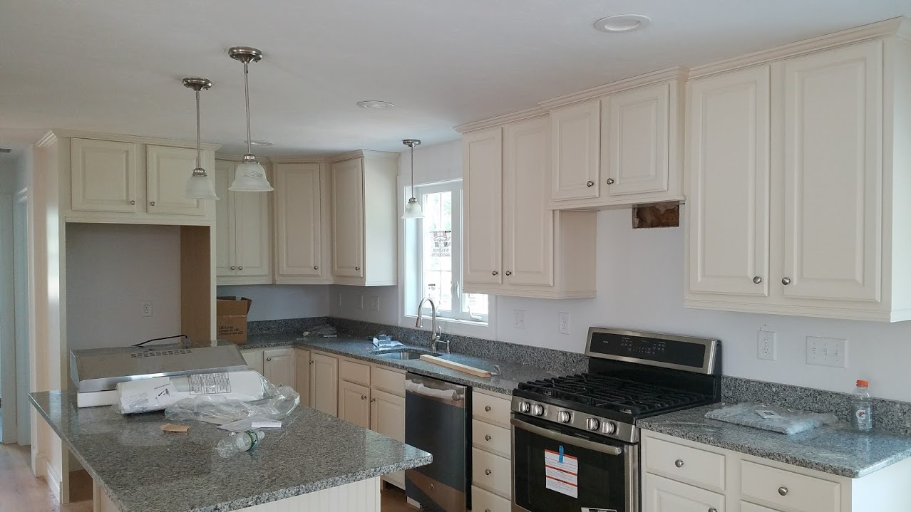 A kitchen with island with white cabinetry