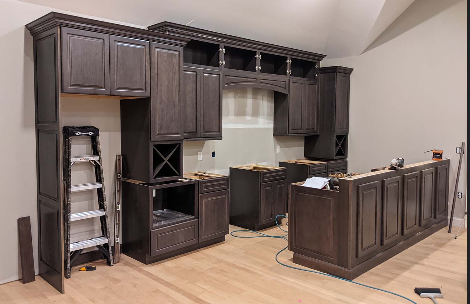 A work-in-progress kitchen with dark-colored cabinetry.