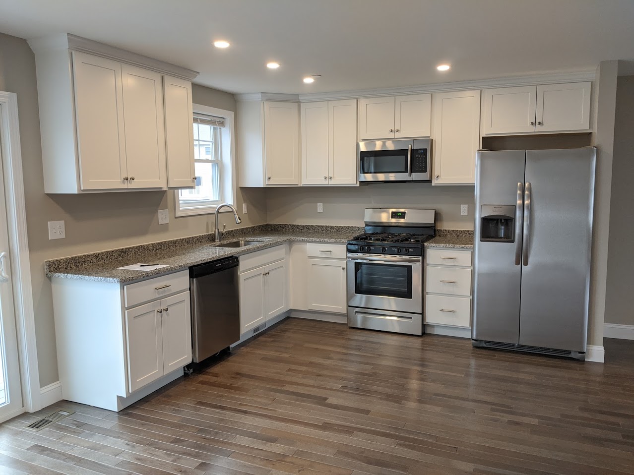 A finished kitchen with white cabinetry.